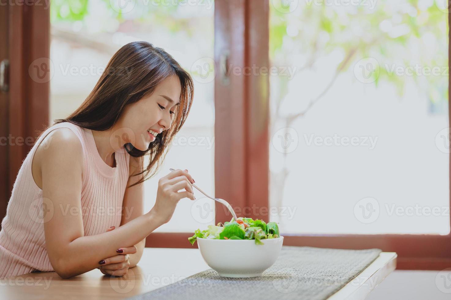 donna sana che mangia insalata foto