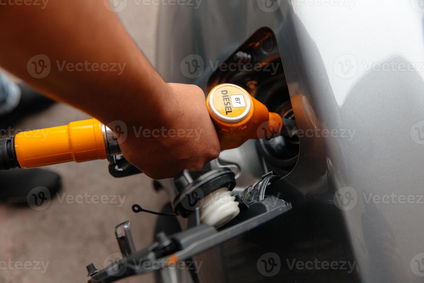 mano uomo ricarica e riempimento carburante gasolio alla stazione. pompaggio di benzina in auto alla stazione di servizio. foto