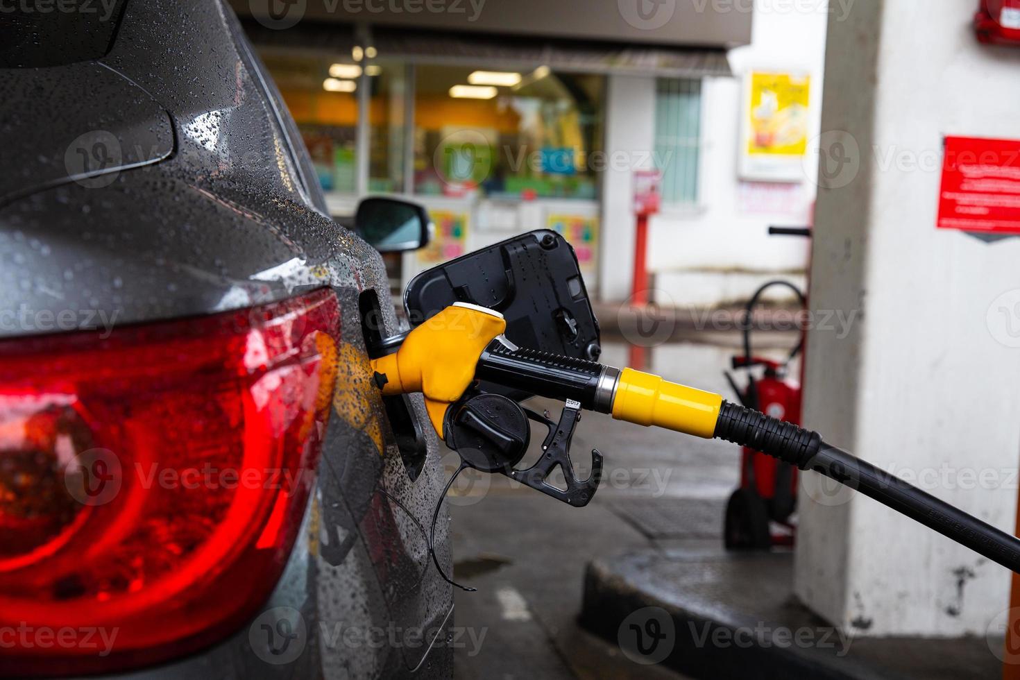 pompaggio di benzina in auto alla stazione di servizio. rifornimento dell'automobile con benzina o diesel con un distributore di carburante. foto