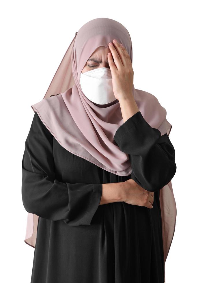 donna musulmana che indossa una maschera chirurgica che si sente male su sfondo bianco foto