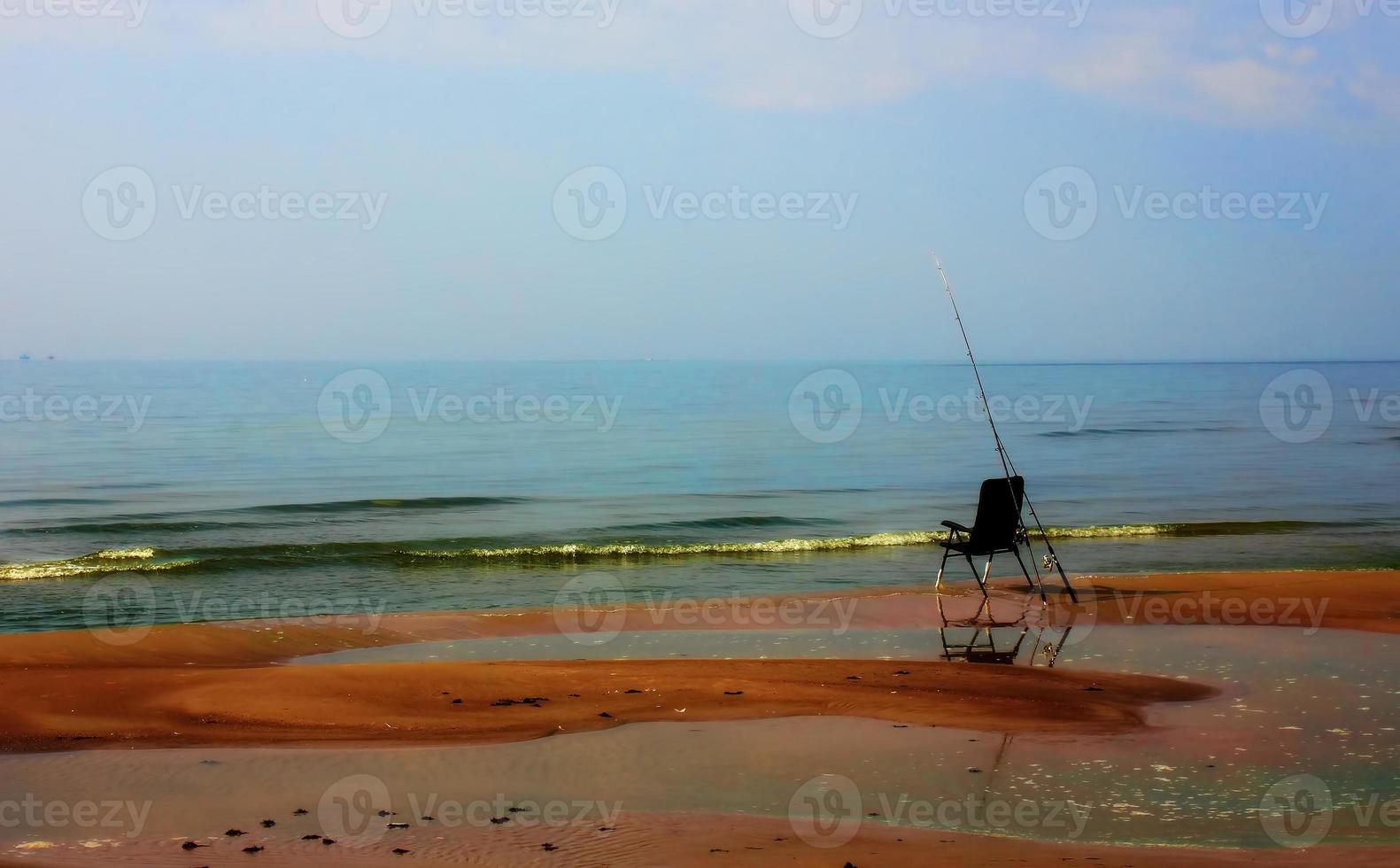 una sedia da pesca solitaria sulla riva a fine estate foto