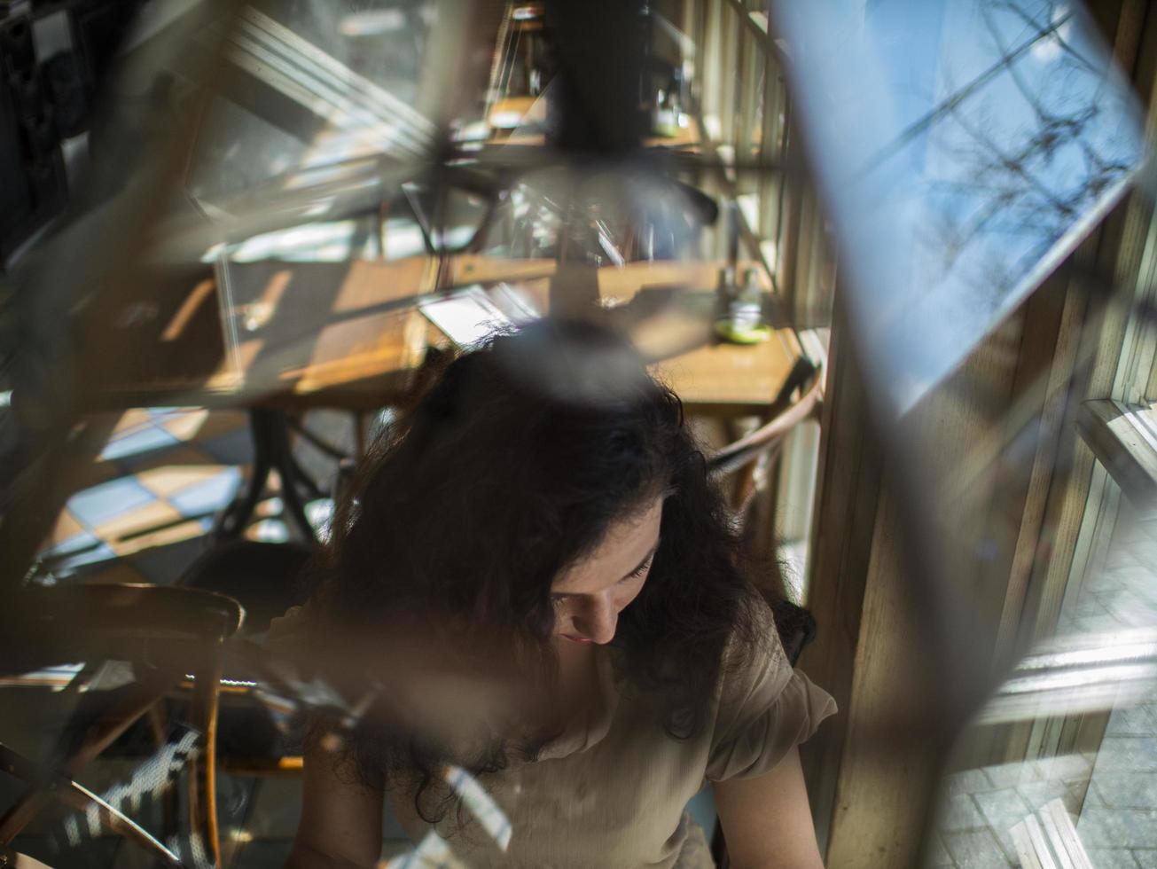 ragazza si siede a un tavolo in un bar e legge un giornale foto