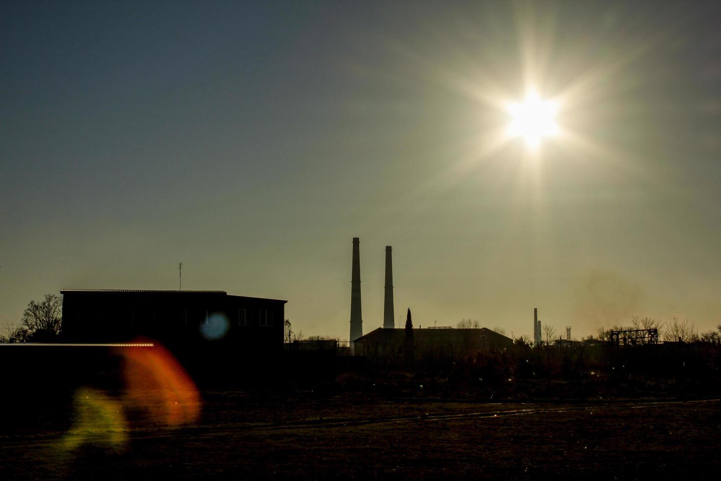 paesaggio industriale con tubi di fabbrica e lens flare foto