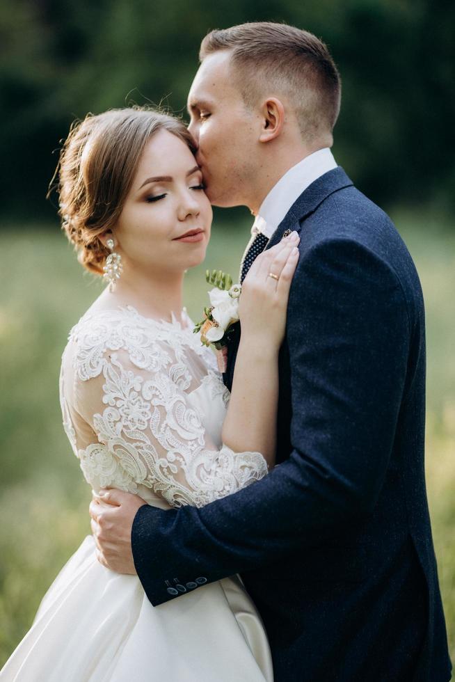 lo sposo e la sposa stanno camminando nella foresta vicino a un fiume stretto foto