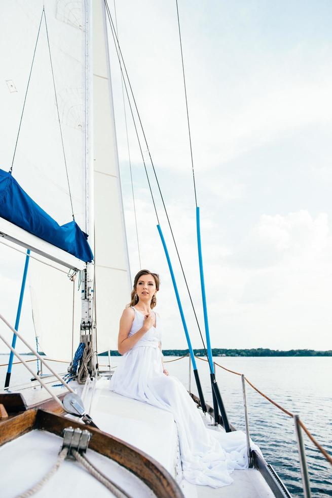 giovane ragazza sul ponte di uno yacht a vela in legno foto