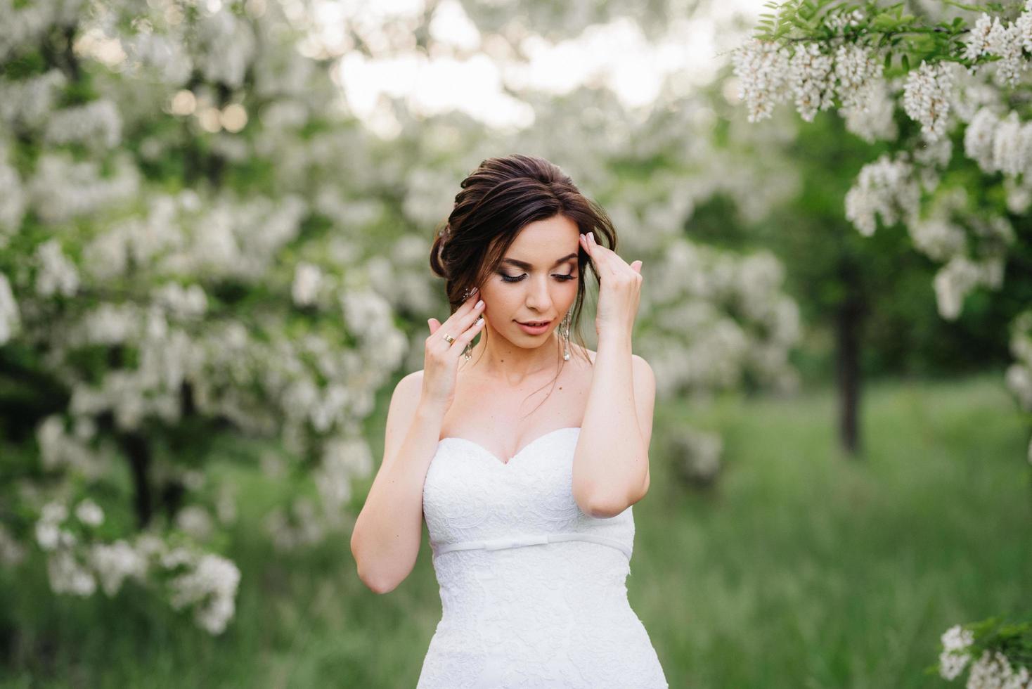 sposa in abito bianco con un grande bouquet primaverile foto