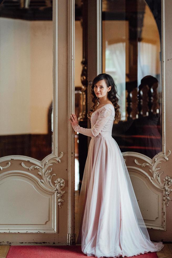 una ragazza con un vestito rosa chiaro sullo sfondo di un castello medievale foto