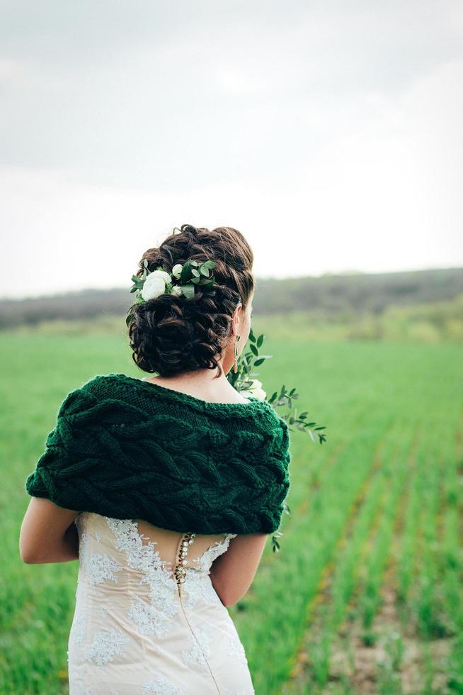 sposa con bouquet in abito avorio e scialle di maglia foto