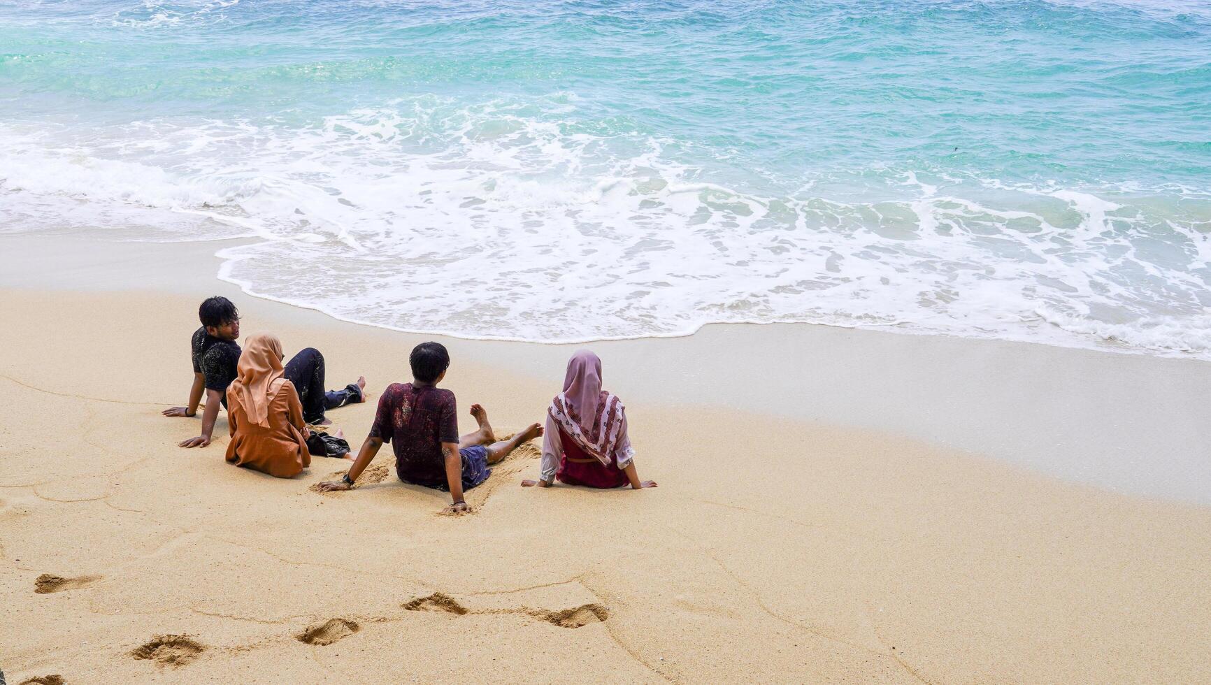 pacitan, indonesia 2021 - amici sulla spiaggia che si godono il mare foto