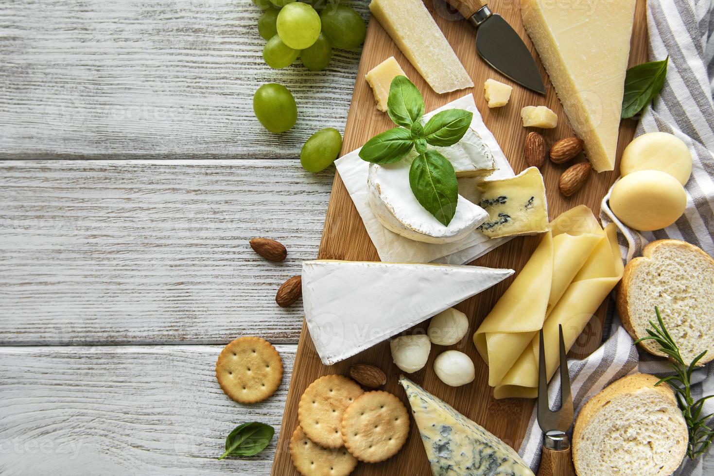 vari tipi di formaggio su uno sfondo di legno bianco foto