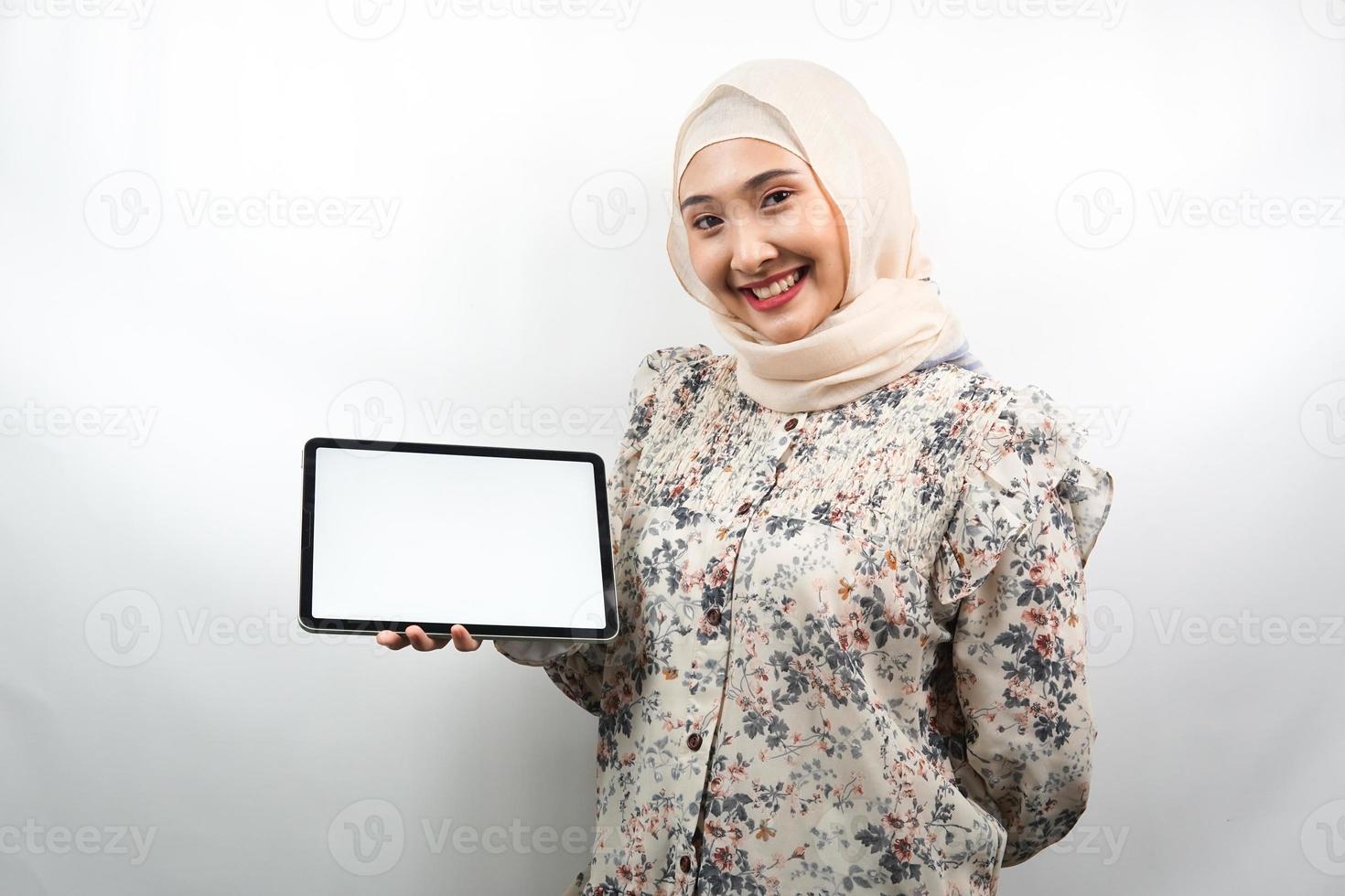 bella giovane donna d'affari musulmana asiatica sicura e sorridente, mani che tengono tablet con schermo bianco o schermo vuoto, presentando qualcosa, presentando il prodotto, presentando il rapporto, isolato foto