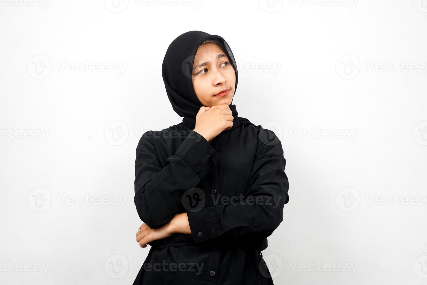 bella giovane donna musulmana asiatica che pensa, guarda lo spazio vuoto, cerca idee isolate su sfondo bianco foto