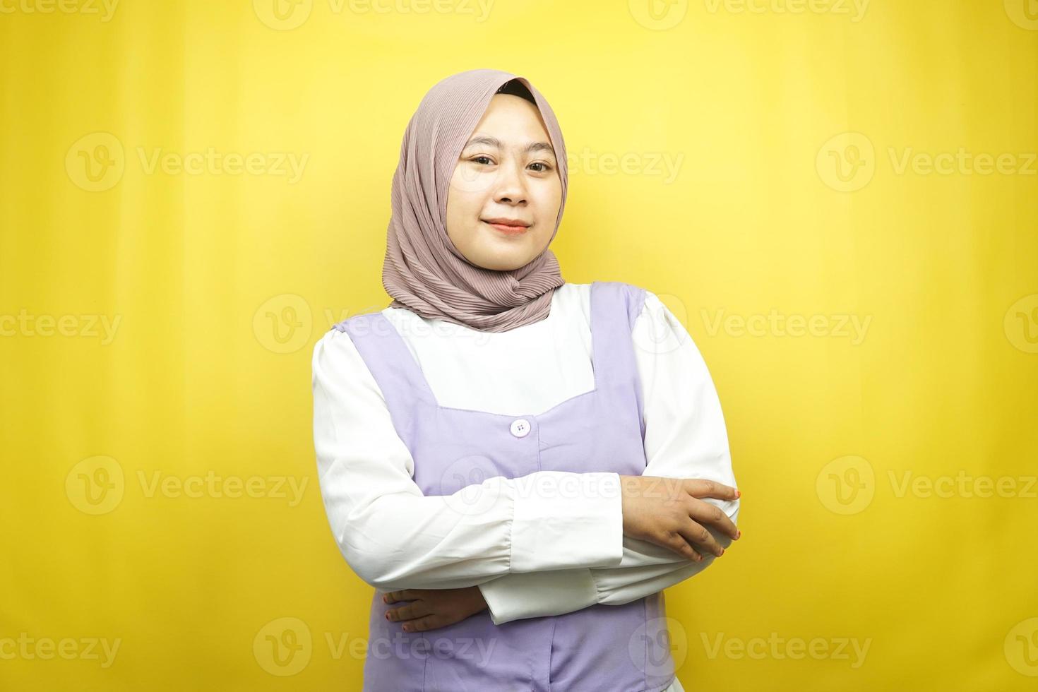 bella giovane donna musulmana asiatica sorridente con fiducia con le braccia tese di fronte alla telecamera isolata su sfondo giallo foto