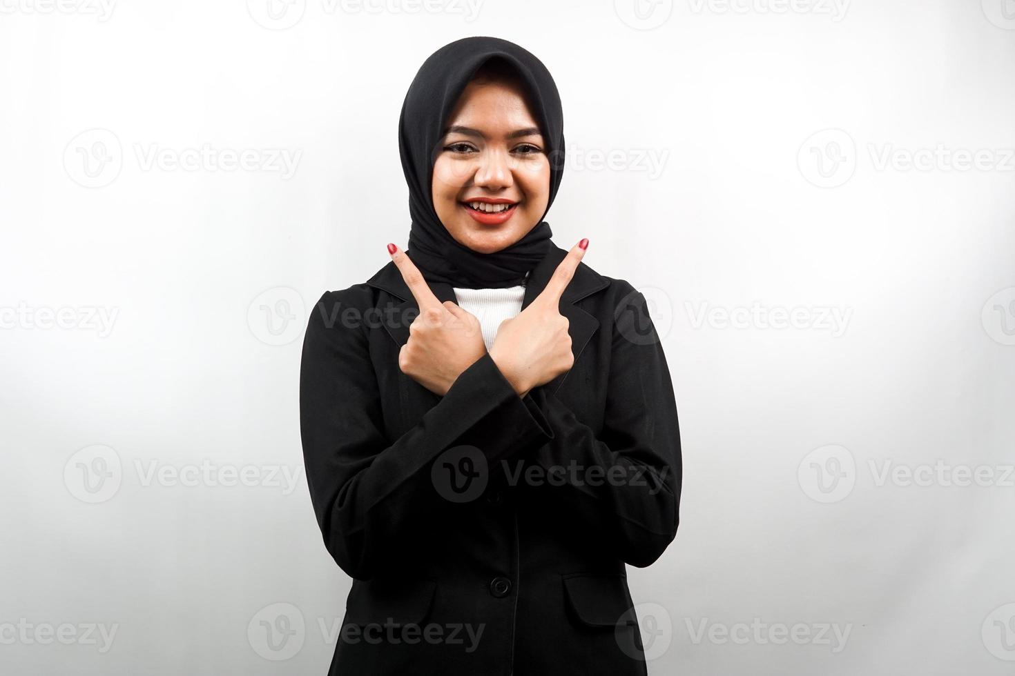 bella giovane donna d'affari musulmana asiatica sorridente sicura di sé, entusiasta, allegra con le mani che puntano lo spazio vuoto presentando qualcosa, guardando la telecamera isolata su sfondo bianco foto