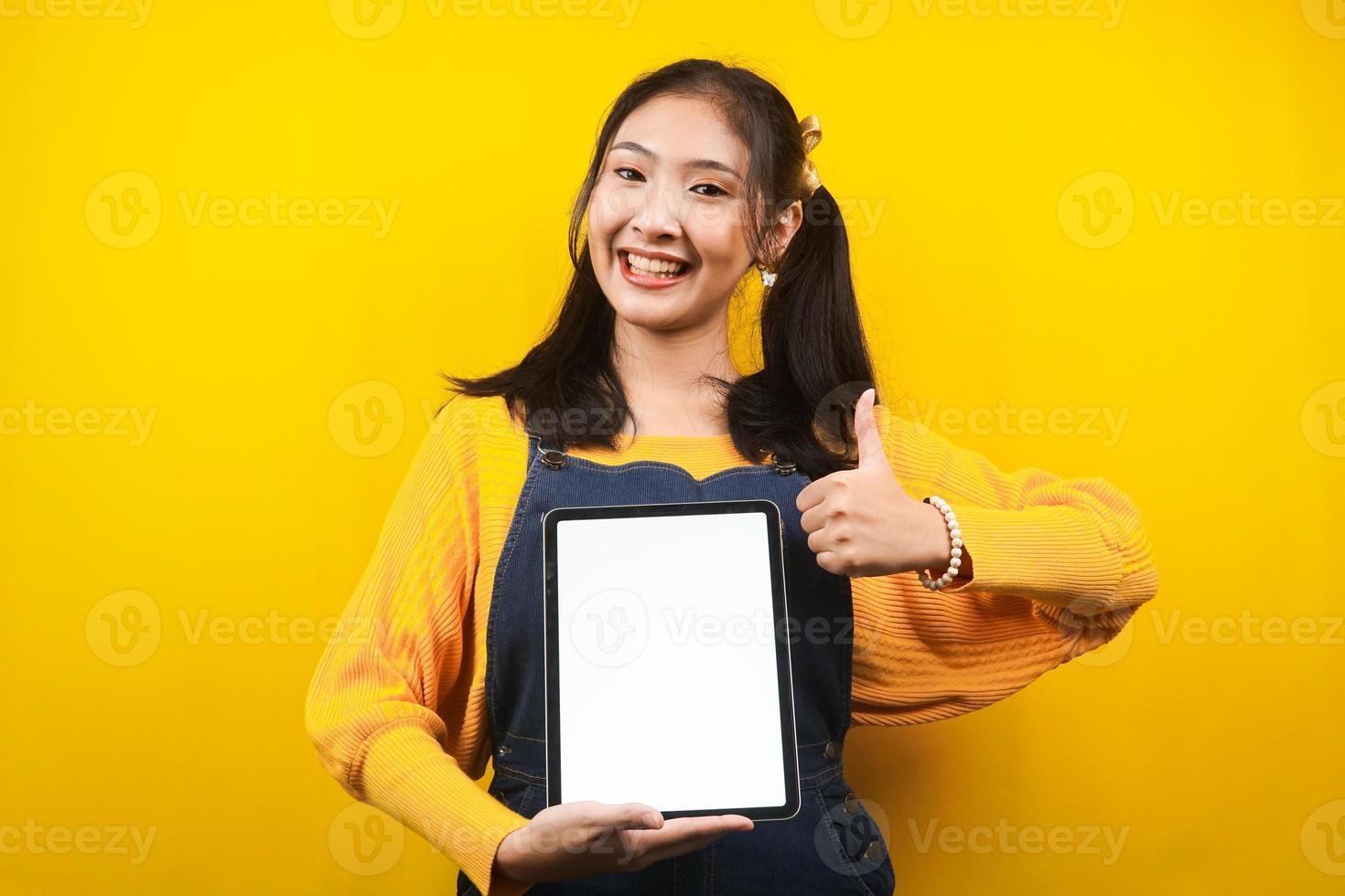 bella e carina giovane donna allegra, sicura di sé, con le mani che tengono tablet, con tablet schermo vuoto o bianco, presentando qualcosa, promuovendo prodotto, pubblicità, isolato foto