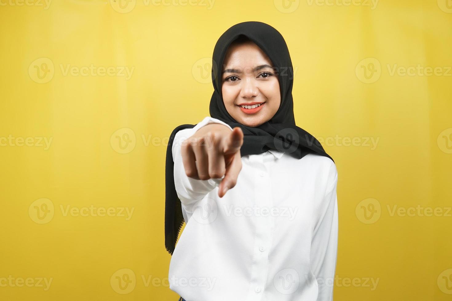 bella giovane donna musulmana asiatica con le mani che puntano alla telecamera, desiderandoti, indicandoti, volendo stare con te, sorridente sicura, entusiasta e allegra, di fronte alla telecamera, isolata foto