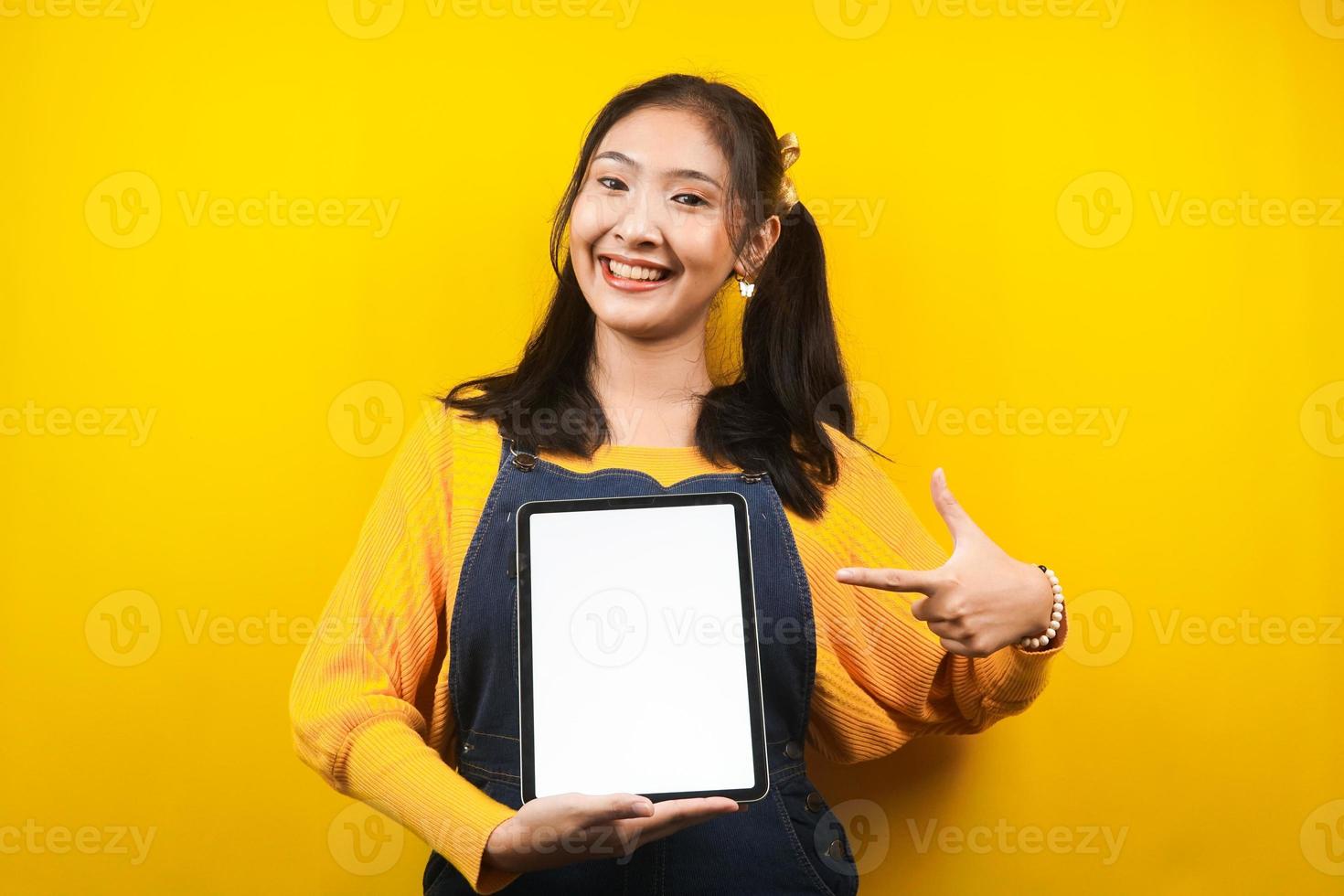 bella e carina giovane donna allegra, sicura di sé, con le mani che tengono tablet, con tablet schermo vuoto o bianco, presentando qualcosa, promuovendo prodotto, pubblicità, isolato foto