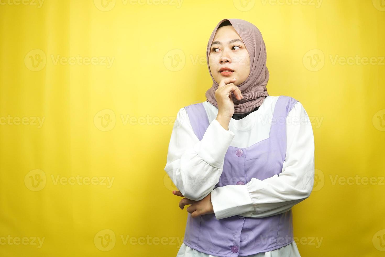 bella giovane donna musulmana asiatica che pensa, c'è un problema, si sente strano, qualcosa non va, cerca una soluzione, isolata su sfondo giallo foto