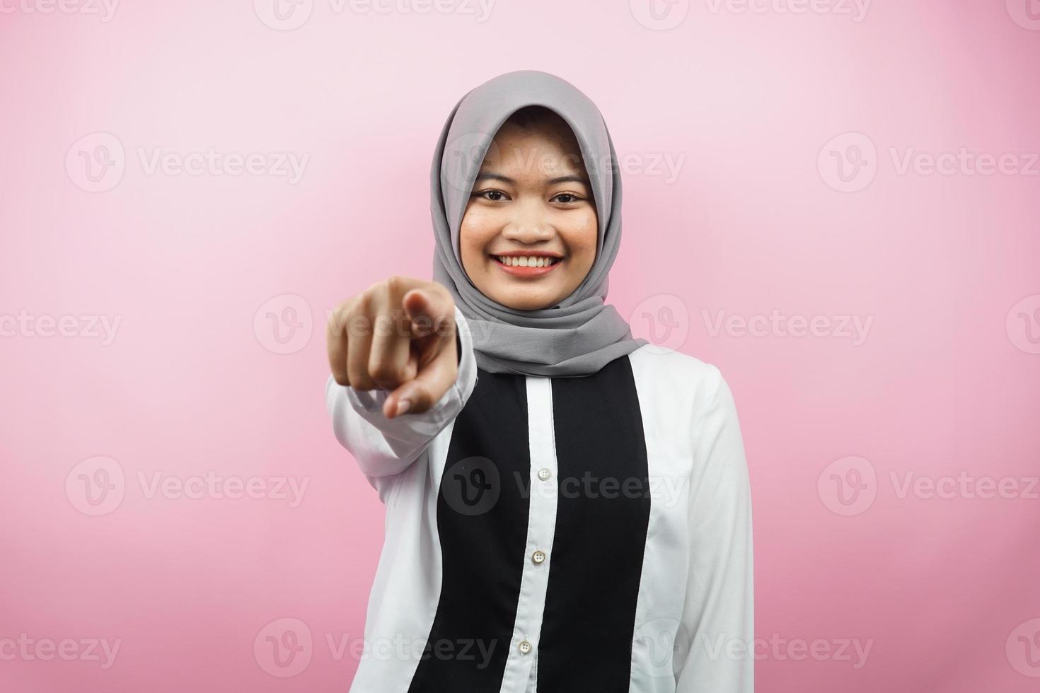 bella giovane donna musulmana asiatica con le mani che puntano alla telecamera, desiderandoti, indicandoti, volendo stare con te, sorridente sicura, entusiasta e allegra, di fronte alla telecamera, isolata foto