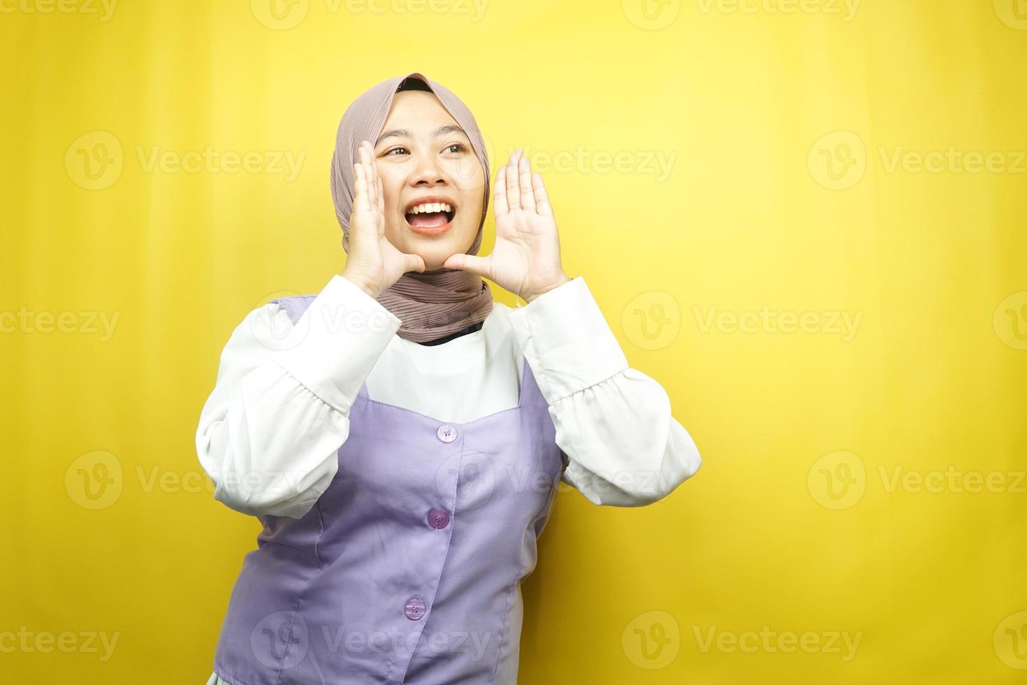 bella giovane donna musulmana asiatica scioccata, incredula, sorpresa, guardando uno spazio vuoto che presenta qualcosa di isolato su uno sfondo giallo foto