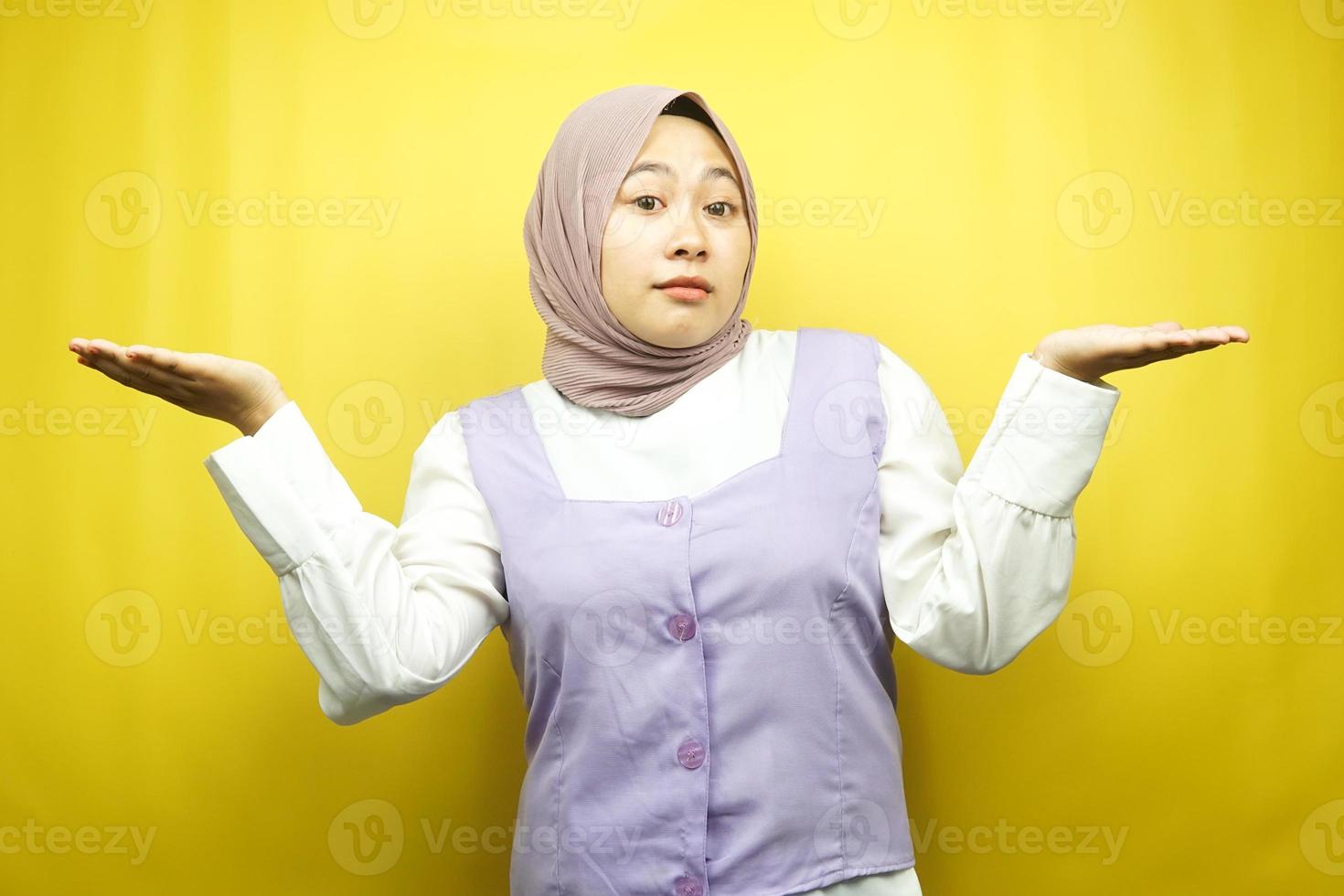 bella asiatica giovane donna musulmana con non so segno espressione, isolata su sfondo giallo foto