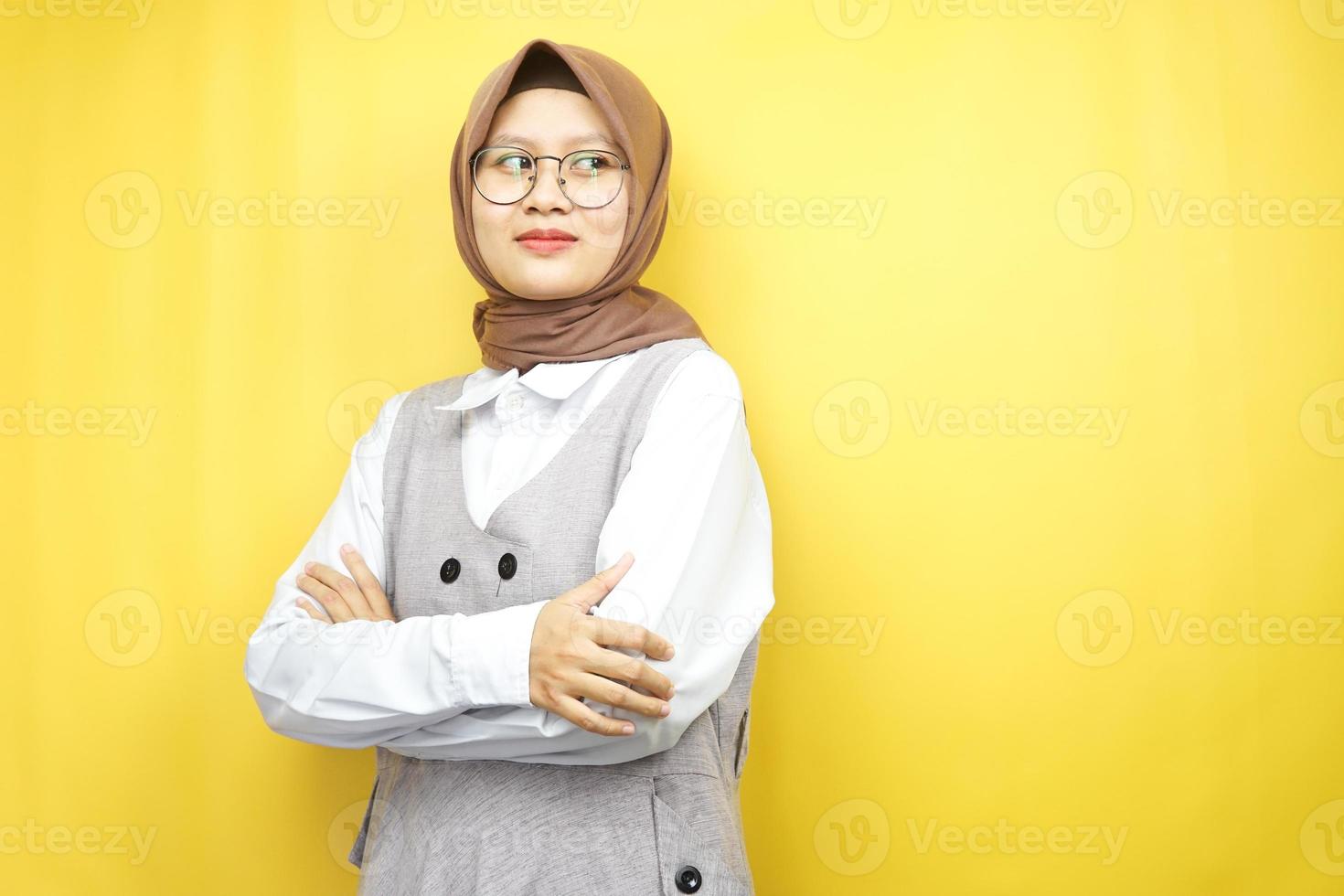bella giovane donna musulmana asiatica pensando, guardando lo spazio vuoto isolato su sfondo giallo foto