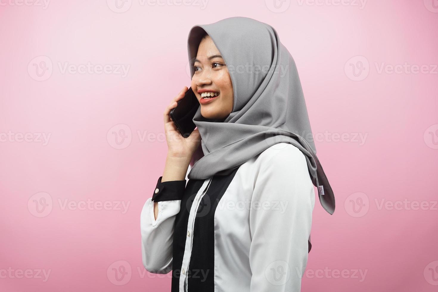 bella giovane donna musulmana asiatica sorridente con fiducia e allegramente chiamando qualcuno, di fronte allo spazio vuoto, isolato su sfondo rosa, concetto pubblicitario foto