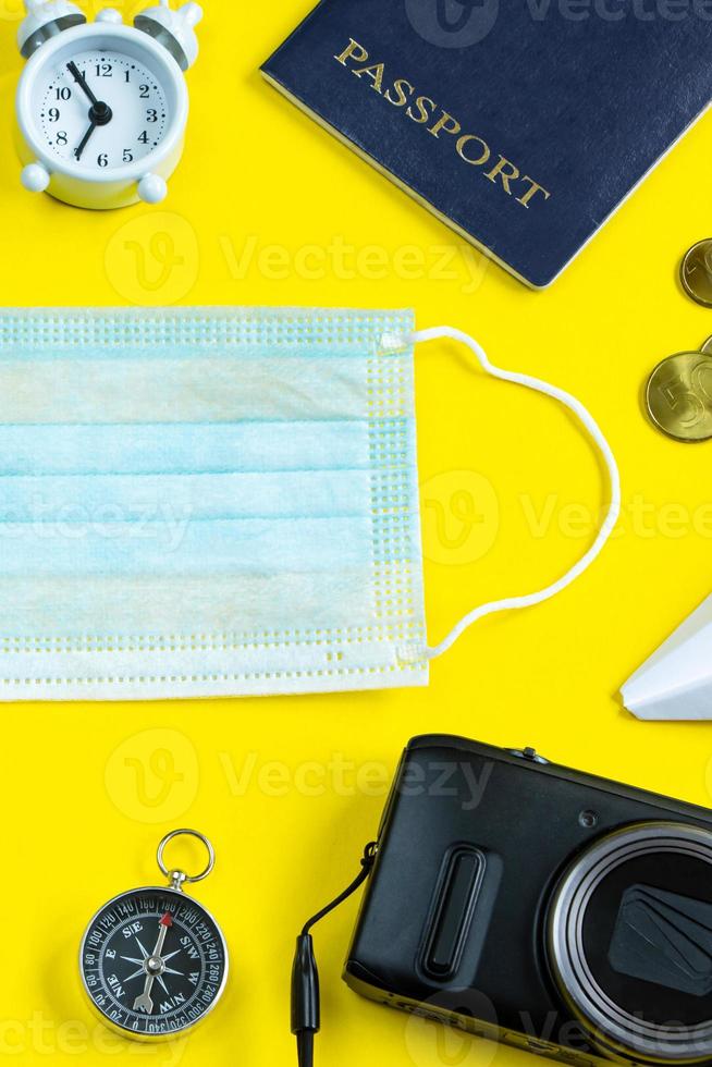 passaporto, blocco note e maschera medica su sfondo blu. foto