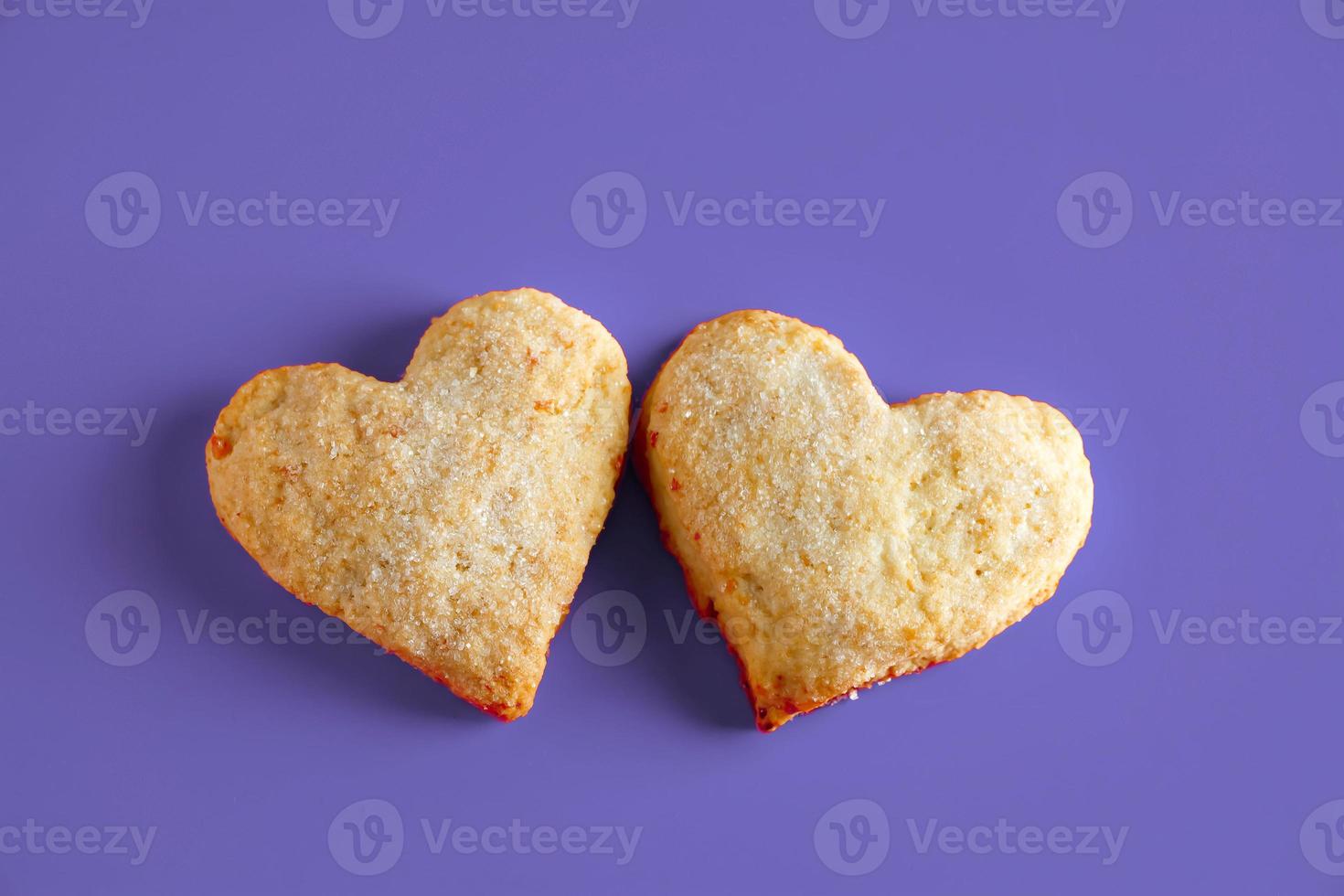 biscotti a forma di cuore per san valentino su sfondo viola. colore alla moda dell'anno 2022. foto