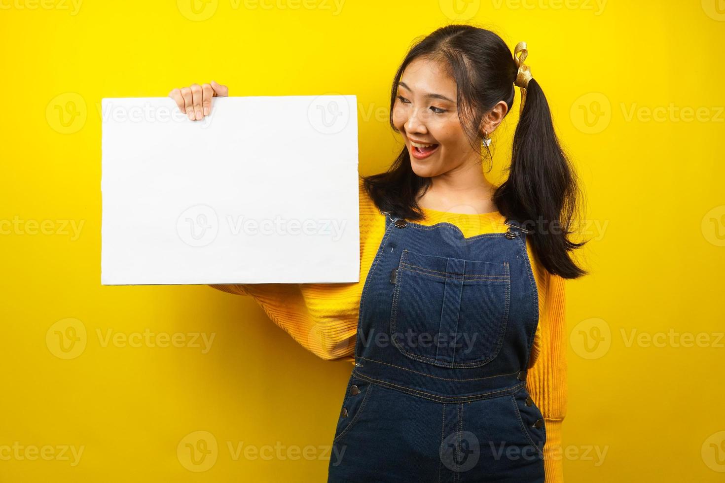 bella e carina giovane donna allegra che tiene in mano un banner vuoto vuoto, cartello, lavagna bianca, cartello bianco, cartellone pubblicitario bianco, presentando qualcosa nello spazio della copia, promozione foto