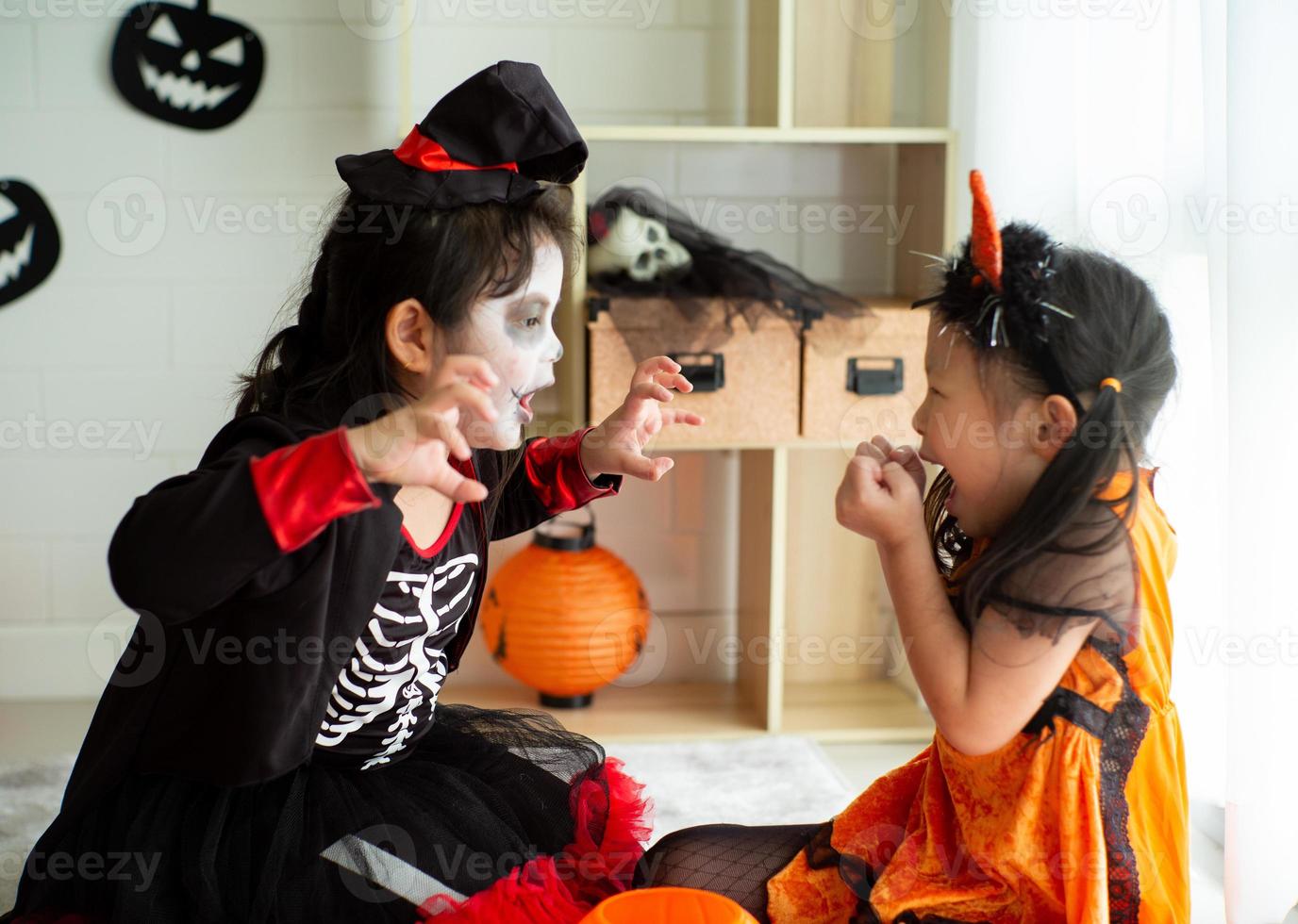 ritratto di due sorelle in costume di halloween che si comportano come un'espressione spaventosa di fantasma l'una con l'altra nel festival di halloween foto