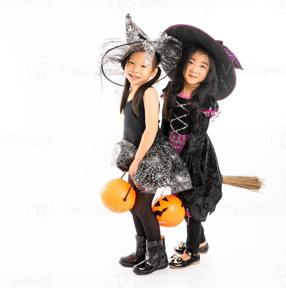 Ritratto di ragazze asiatiche in costume di halloween che cavalcano insieme la scopa e raccolgono la zucca con sfondo isolato foto