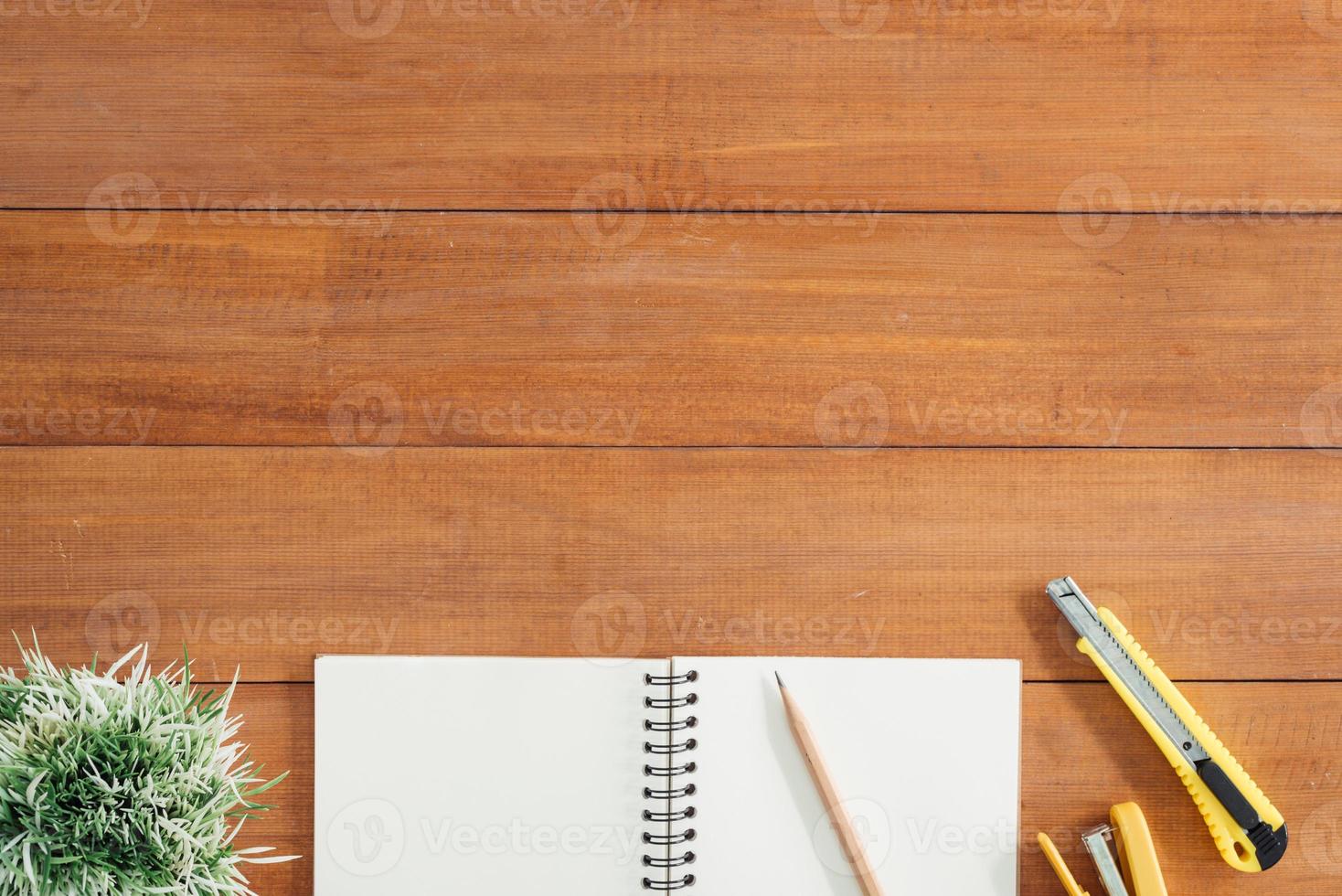 spazio di lavoro minimo - foto creativa piatta della scrivania dell'area di lavoro. sfondo tavolo in legno scrivania ufficio con mock up quaderni e penne e pianta aperti. vista dall'alto con spazio di copia, fotografia piatta.