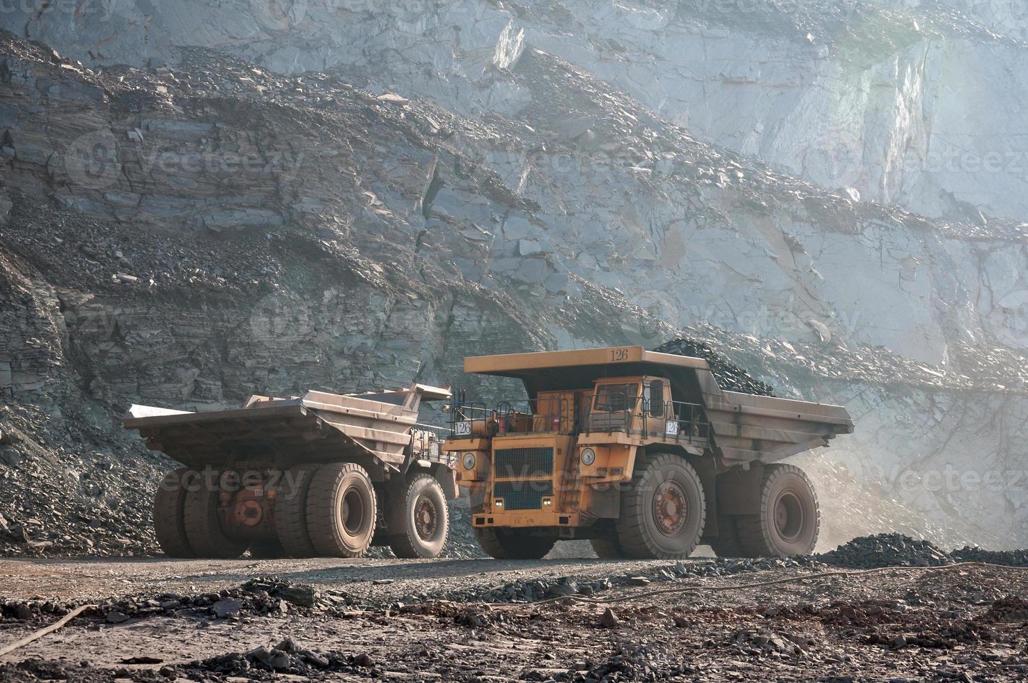 I dumper da miniera a cielo aperto guidano da soli l'area industriale della cava di minerale di ferro foto