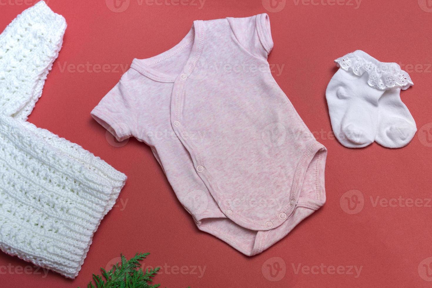 natale rosa baby body mockup su sfondo colorato close up con giacca bianca lavorata a maglia vestiti per neonati mockup. con copia spazio foto