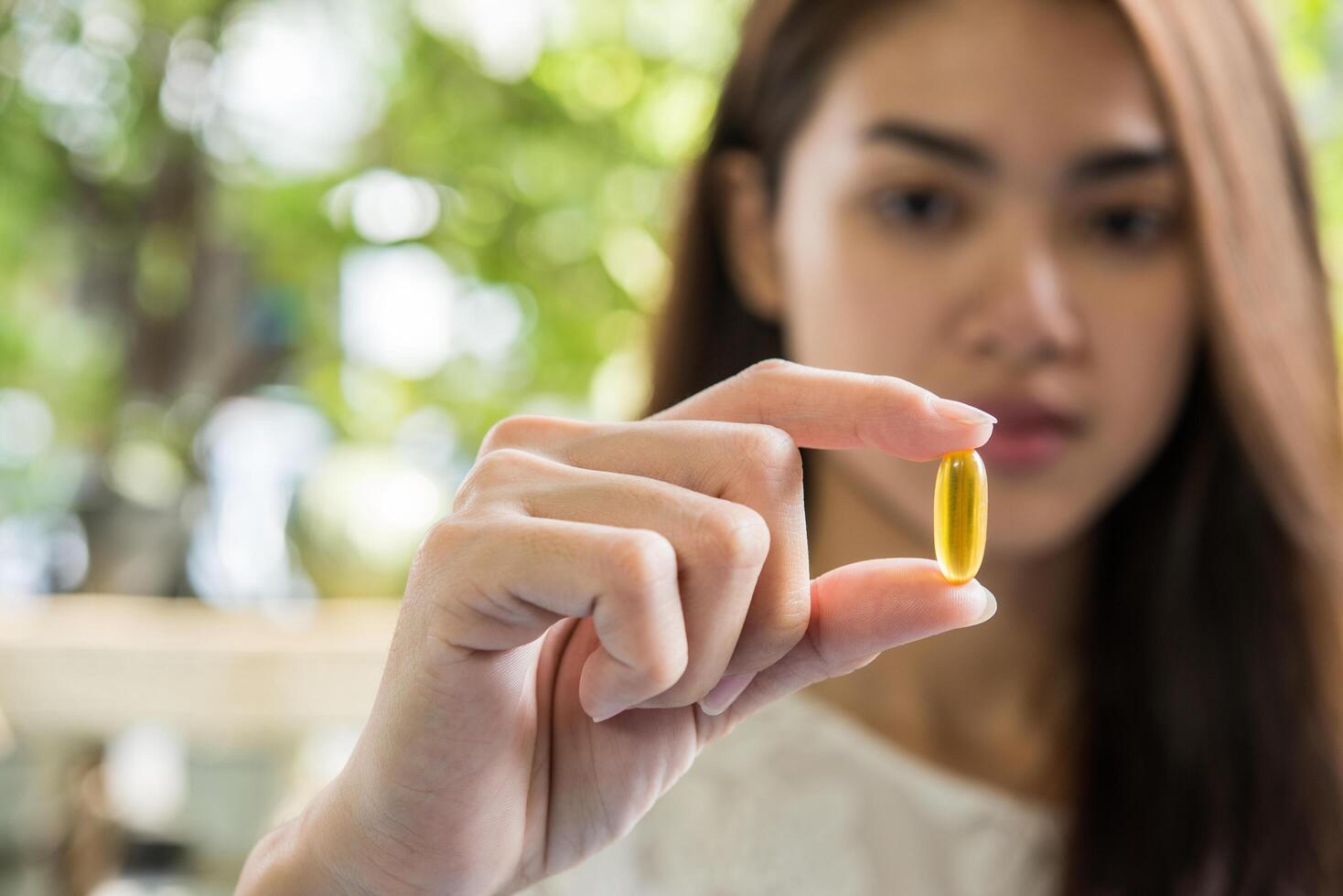 la mano della donna che tiene una pillola prende la medicina secondo l'ordine del medico foto