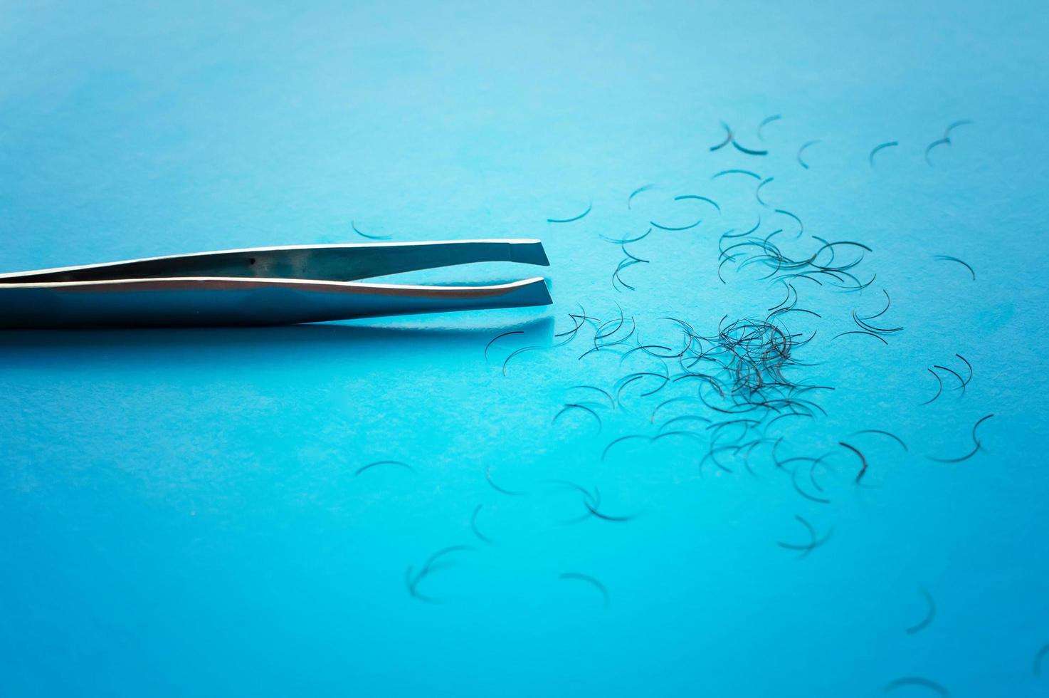 pinzette per strappare sopracciglia e capelli su uno sfondo blu con un posto per scrivere foto