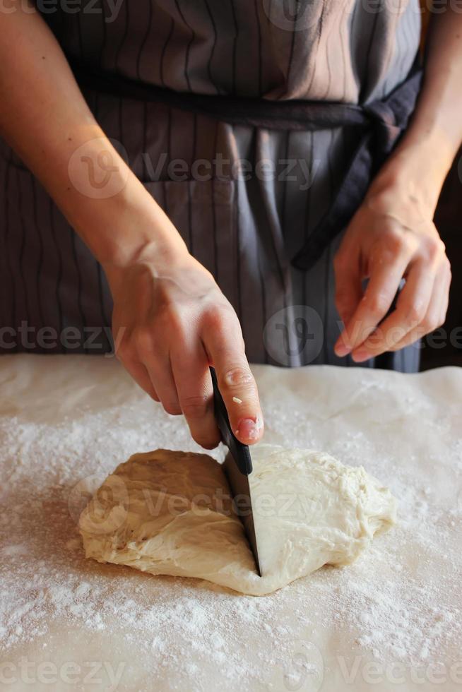 domestico. le mani di una donna tagliano la pasta per la cottura. festa di famiglia. foto