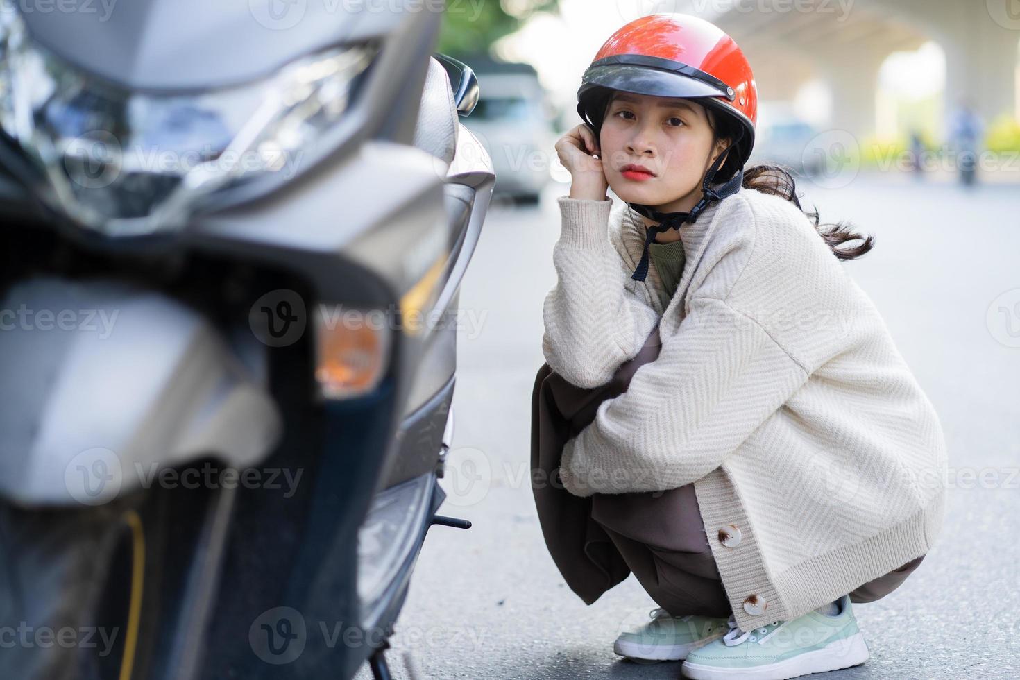 ragazza asiatica ha rotto la sua moto mentre andava al lavoro foto