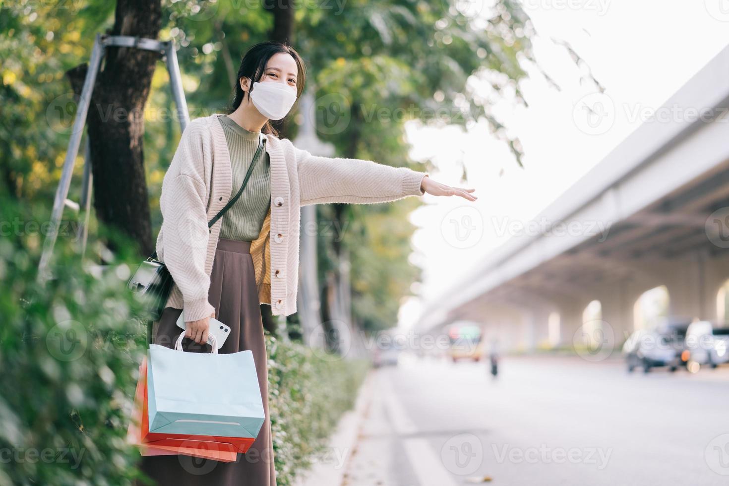 donna asiatica che indossa una maschera mentre cammina per strada foto