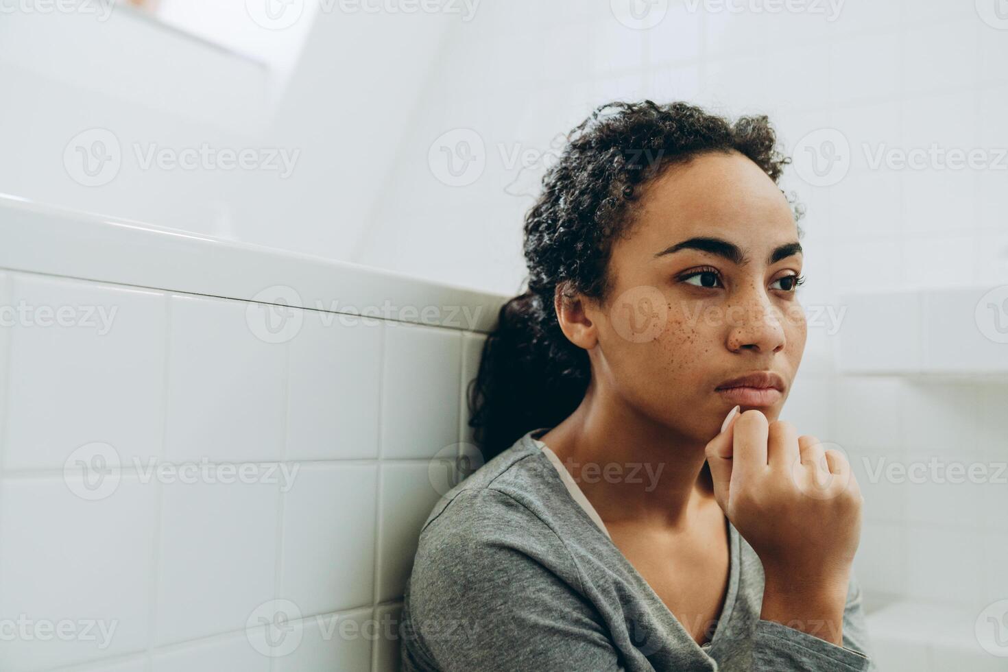 giovane donna di colore che guarda da parte mentre passa il tempo a casa foto