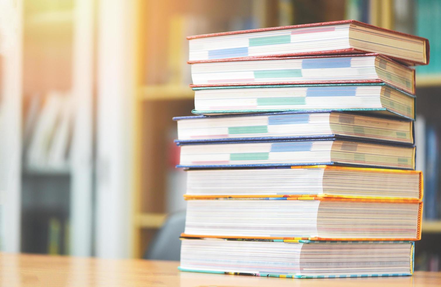 Prenota il concetto di educazione torna a scuola e studia - libri impilati in biblioteca sul tavolo foto