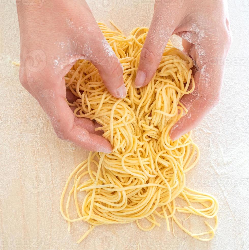 pasta fatta in casa con mani di donna foto