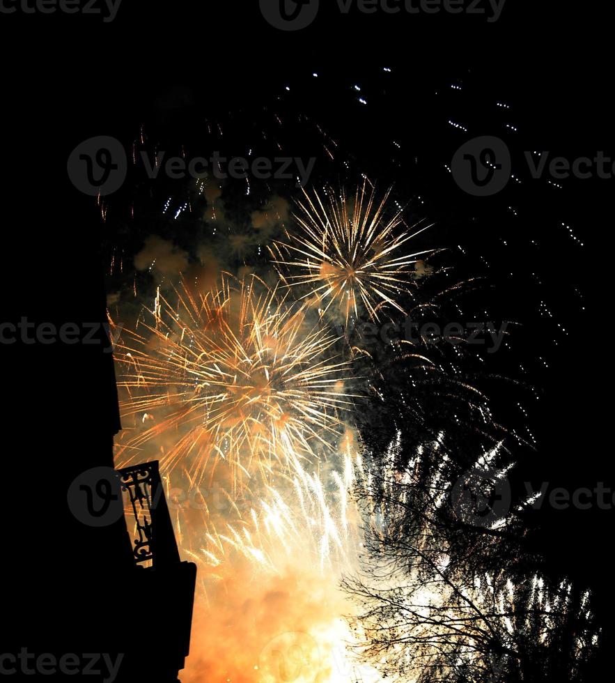 scoppiano fuochi d'artificio colorati nel cielo notturno scuro foto