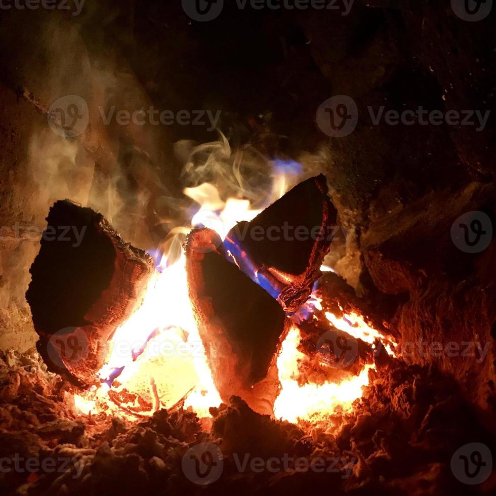 bella fiamma di legno marrone carbone nero scuro su fuoco giallo brillante all'interno di un braciere in metallo foto