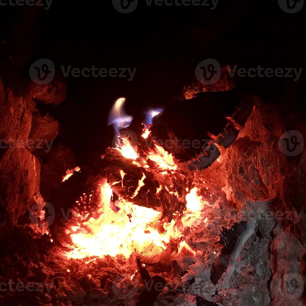 bella fiamma di legno marrone carbone nero scuro su fuoco giallo brillante all'interno di un braciere in metallo foto