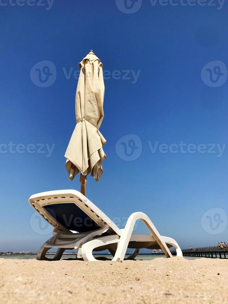 elegante lettino in sabbia gialla per prendere il sole sulla spiaggia in estate a cielo aperto foto