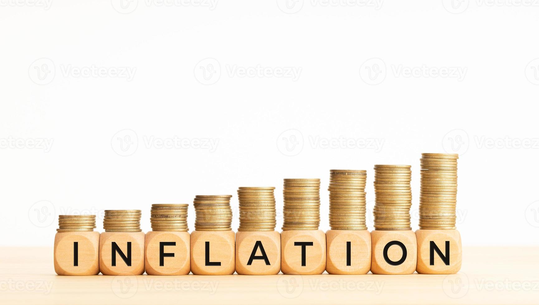 concetto di inflazione. testo su blocchi di legno e monete impilate. copia spazio foto