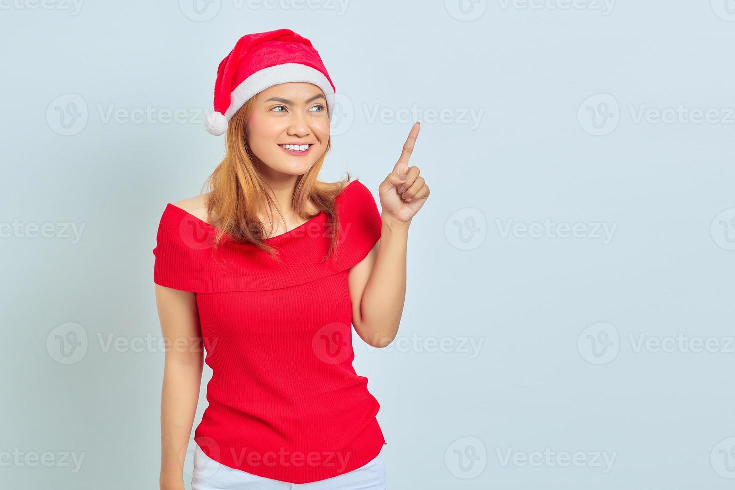 ritratto di giovane donna asiatica che indossa abito natalizio in piedi sorridente e toccante sullo schermo trasparente. concetto di natale foto