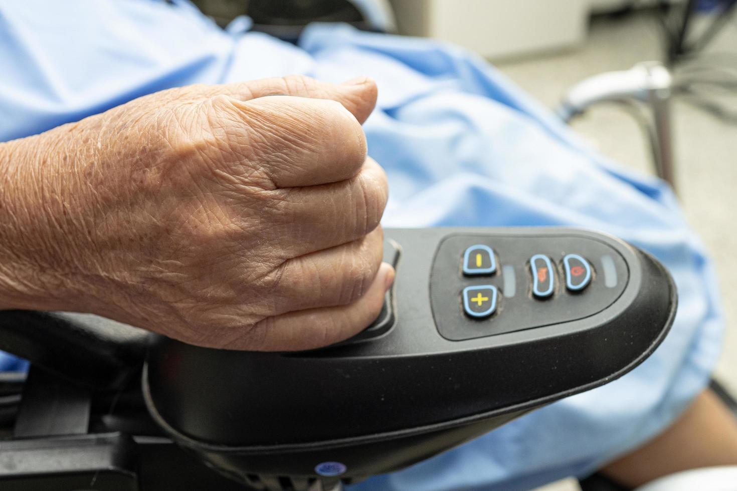 paziente asiatico anziana o anziana signora anziana su sedia a rotelle elettrica con telecomando nel reparto ospedaliero di cura, concetto medico sano e forte foto